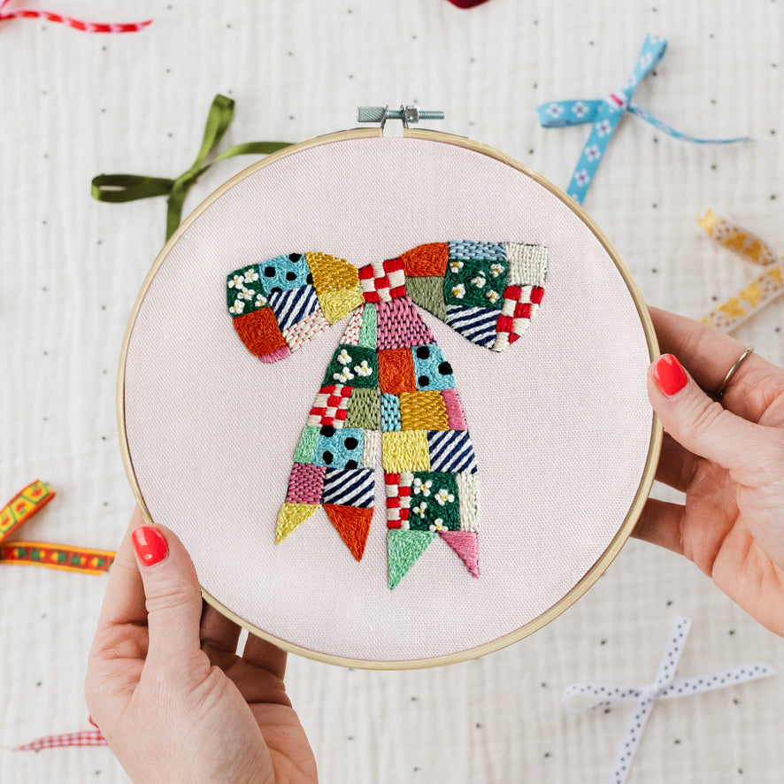 Stitched Cotton Clara Hoop Club Quilted Bow design being held in an embroidery hoop